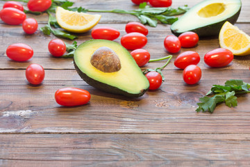 Ingredients for sauce guacamole. Fresh vegetables - avocado, tomatoes, cilantro and lemon. Vegetarian o healthy food concept