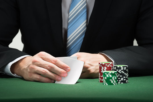 Poker Player Hand With Cards And Chips