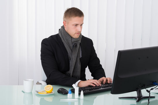 Sick Businessman Using Computer In Office
