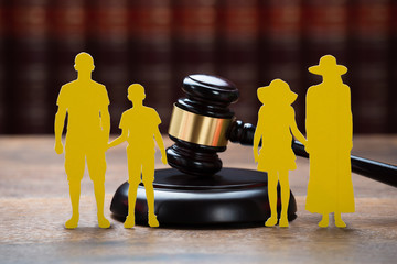 Paper Family With Mallet On Table In Courtroom