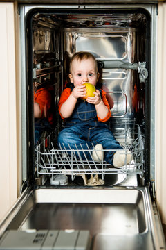 Baby Eating Apple In Dishwasher