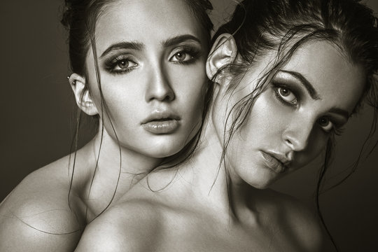 Two young attractive womans closeup face portrait. Fashion style