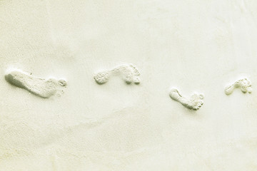 Traces of bare feet in the sand on a tropical island, Maldives.