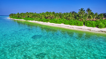 Shoreline of a tropical island in the Maldives and view of the I