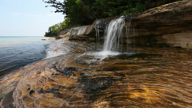 Seamless loop features Elliot Falls, a small but beautiful waterfall that splashes over layered rock and into Lake Superior on the Michigan coast at Pictured Rocks National Lakeshore.