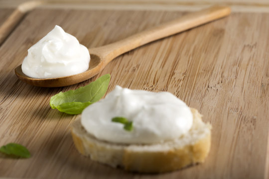 Cream cheese in wooden spoon