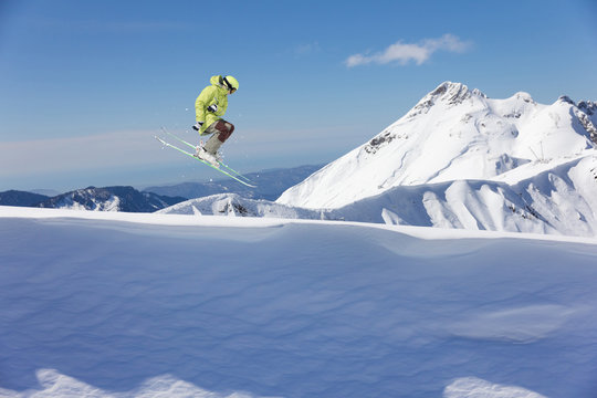 Flying skier on mountains. Extreme sport.