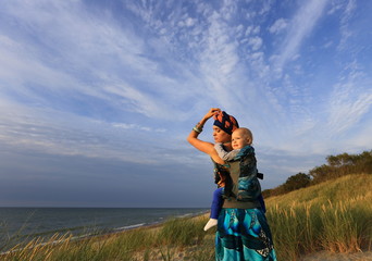 Woman on the beach with a child to carry.