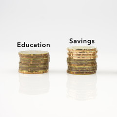 Coins stack in row with Education and Savings label on white background, financial concept.
