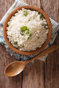 Cauliflower rice with basil in a bowl close-up. Vertical top view
