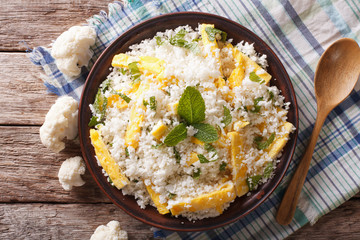 Cauliflower rice with scrambled eggs and herbs closeup. horizontal top view
