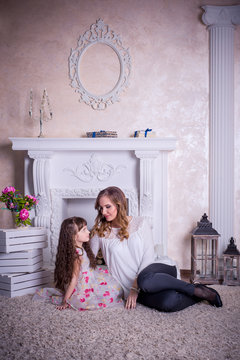 Studio photo mother and daughter in a beautiful interior