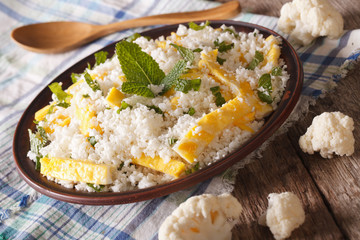 Cauliflower rice with scrambled eggs and mint close-up. horizontal
