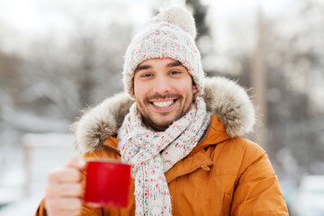 happy man with tea cup outdoors in winter