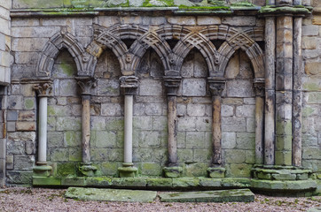 Ancient gothic stone wall with arches and columns, ruins uk