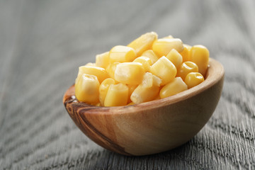 sweet canned corn in wood bowl on wood table