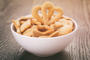 heart cookies for valentines day in white bowl on wood table