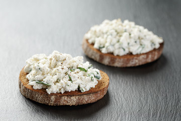 two rye sandwiches or bruschettarye open sandwich with cream cheese and herbs on slate