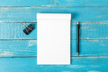 Top view of Lined note paper with pencil on blue wood table for
