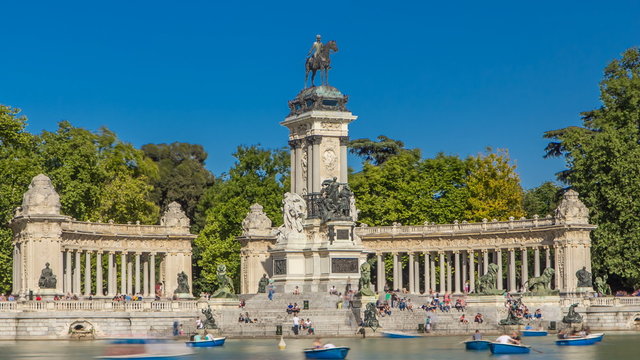 Tourists on boats at Monument to Alfonso XII timelapse hyperlapse in the Parque del Buen Retiro - Park of the Pleasant Retreat in Madrid, Spain