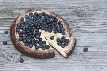 Sliced cheesecake New York  with blueberry on a wood background