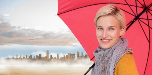 Composite image of smiling woman holding an umbrella