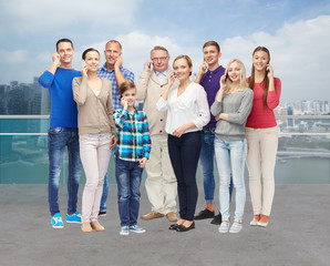 group of smiling people with smartphones