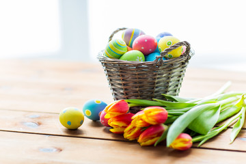 close up of easter eggs in basket and flowers