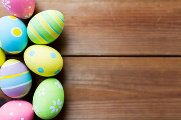 close up of colored easter eggs on wooden surface