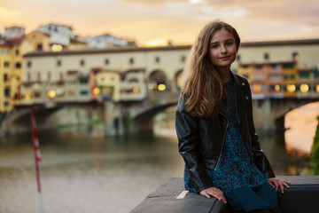 Portrait of young and beautiful girl in Florence, Italy. In background bridge Ponte Vecchio