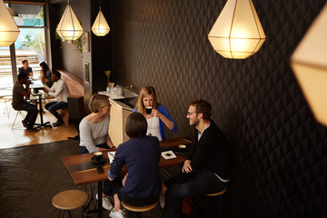Fototapeta na wymiar Friends talking while enjoying fresh coffee in a cafe together