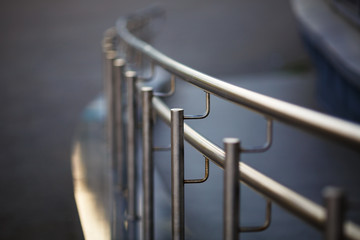 Chromium metal fence with handrail. Shallow depth of field. Selective focus.