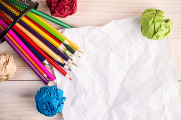 Creased color papers pencils and office bin