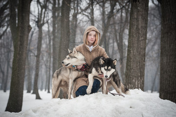Fototapeta na wymiar A teen girl with two husky dogs 