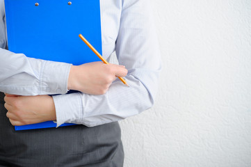 Business woman close up. Folder and pencil in hand.