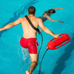 Lifeguard jumping towards drowning victim in the pool