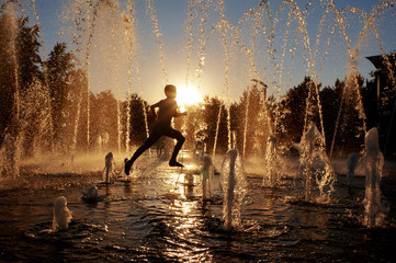 boy running through a fountain