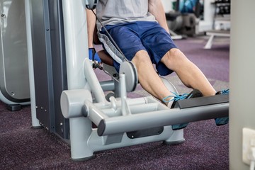 Focused man using weights machine for legs