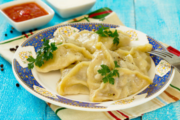 Steam the dumplings with meat and cabbage on a wooden table