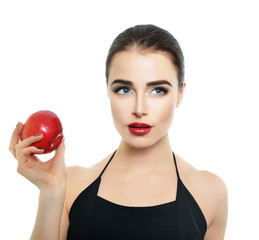 Portrait of beautiful young woman holding red apple near her fac