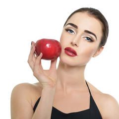 Portrait of beautiful young woman holding red apple near her fac