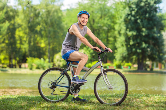 Active senior man riding a bike in park