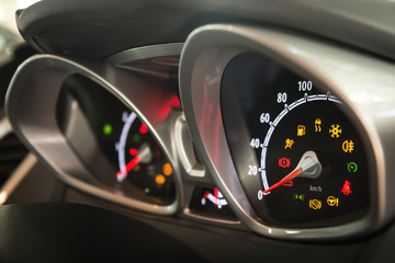 Modern car dashboard left side view. Show all led signs. (Focus on speedometer indicator and...