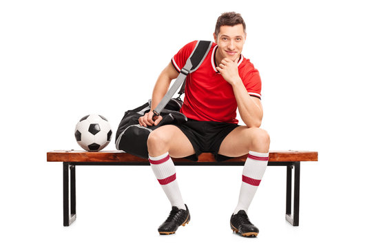 Young football player sitting on a bench