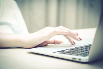 woman working with laptop, finger touch on touch pad