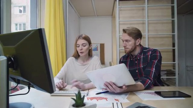 A bearded man with a laptop showing the employee data that she enters into your computer.