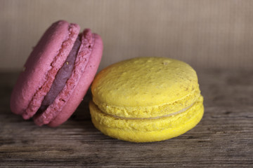 Colorful French macaroons on a dark  wooden background, selective focus