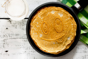 Oatmeal pancakes in a frying pan on a white wooden table