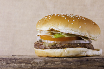 Burger on an old wooden board vintage background