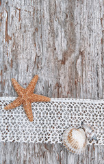 Fototapeta na wymiar Shabby chic background with seashells and lace on old wood